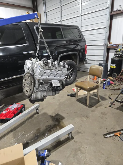Engine hoist beside a vehicle in the shop